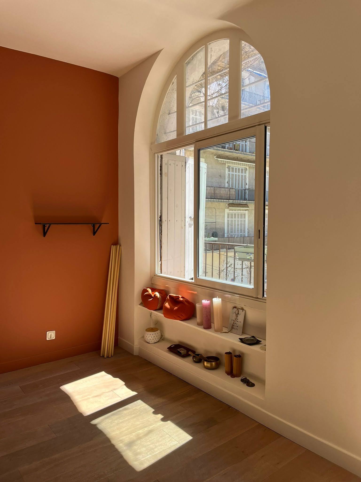 La salle, sa grande fenêtre en arc et la lumière du matin sur le parquet