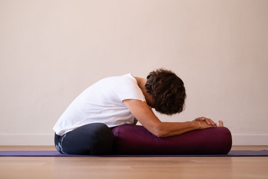 Flexion avant, le buste posé sur un bolster